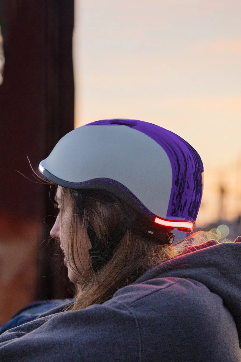 Girl at sunset wearing Lumos Nyxel Kids in Purple Overspray with the rear light on